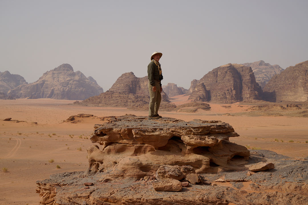 Filmmaker Tim Mahoney stands atop a rock formation in Jordan